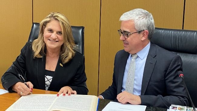 Sílvia Massruhá assina o livro de posse na reunião do Consad, ao lado do presidente do colegiado, Guilherme Soria. Fonte: Embrapa.